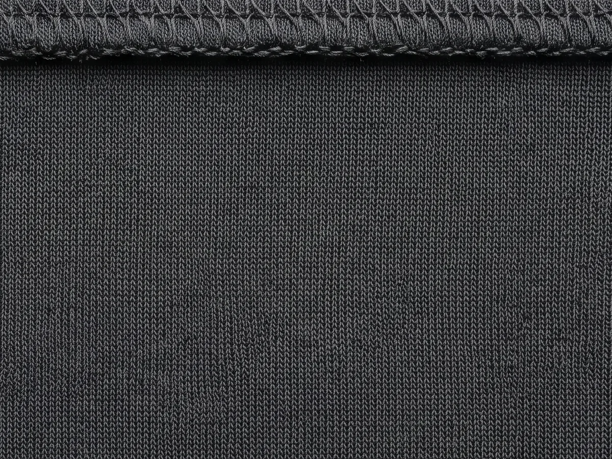 Close view of a dark technical face cloth with an overlocked edge running across it
