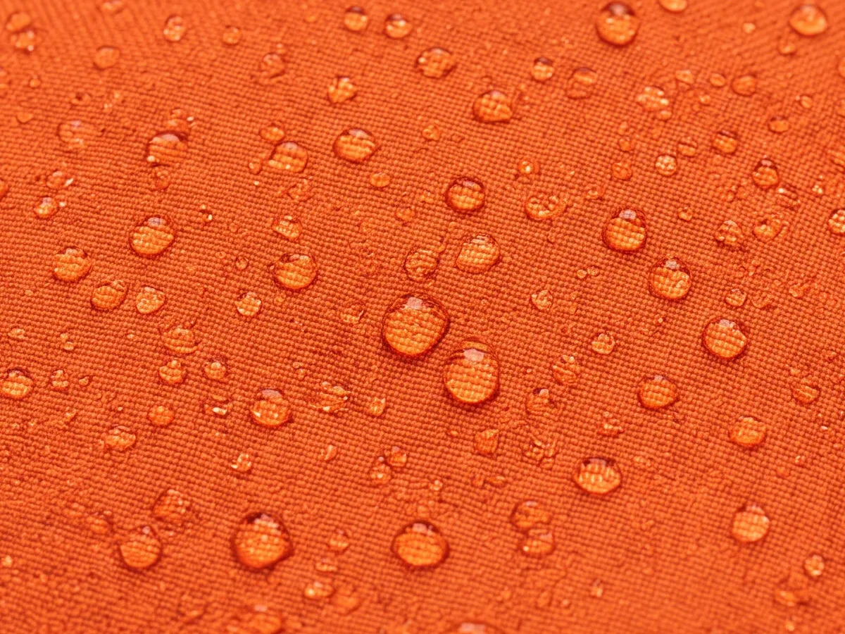 Close view of a coated orange outer-layer face with water beading on the surface