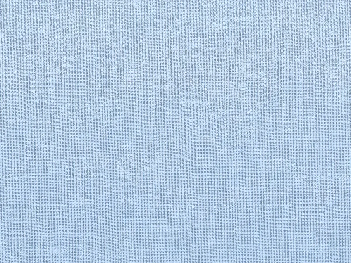 A cut swatch of plain pale blue fabric with pinked edges, lying on white
