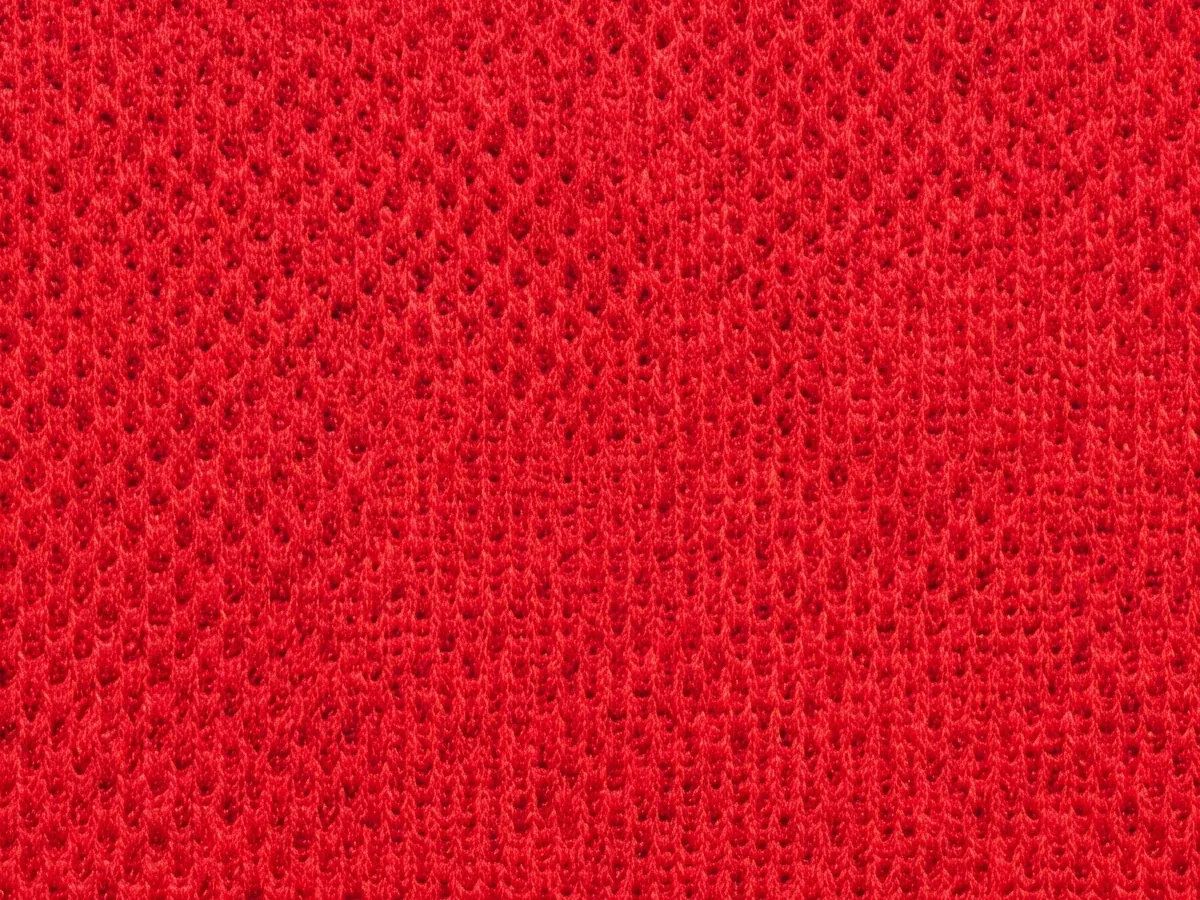 Close view of a red technical pique face, the loop structure clearly visible