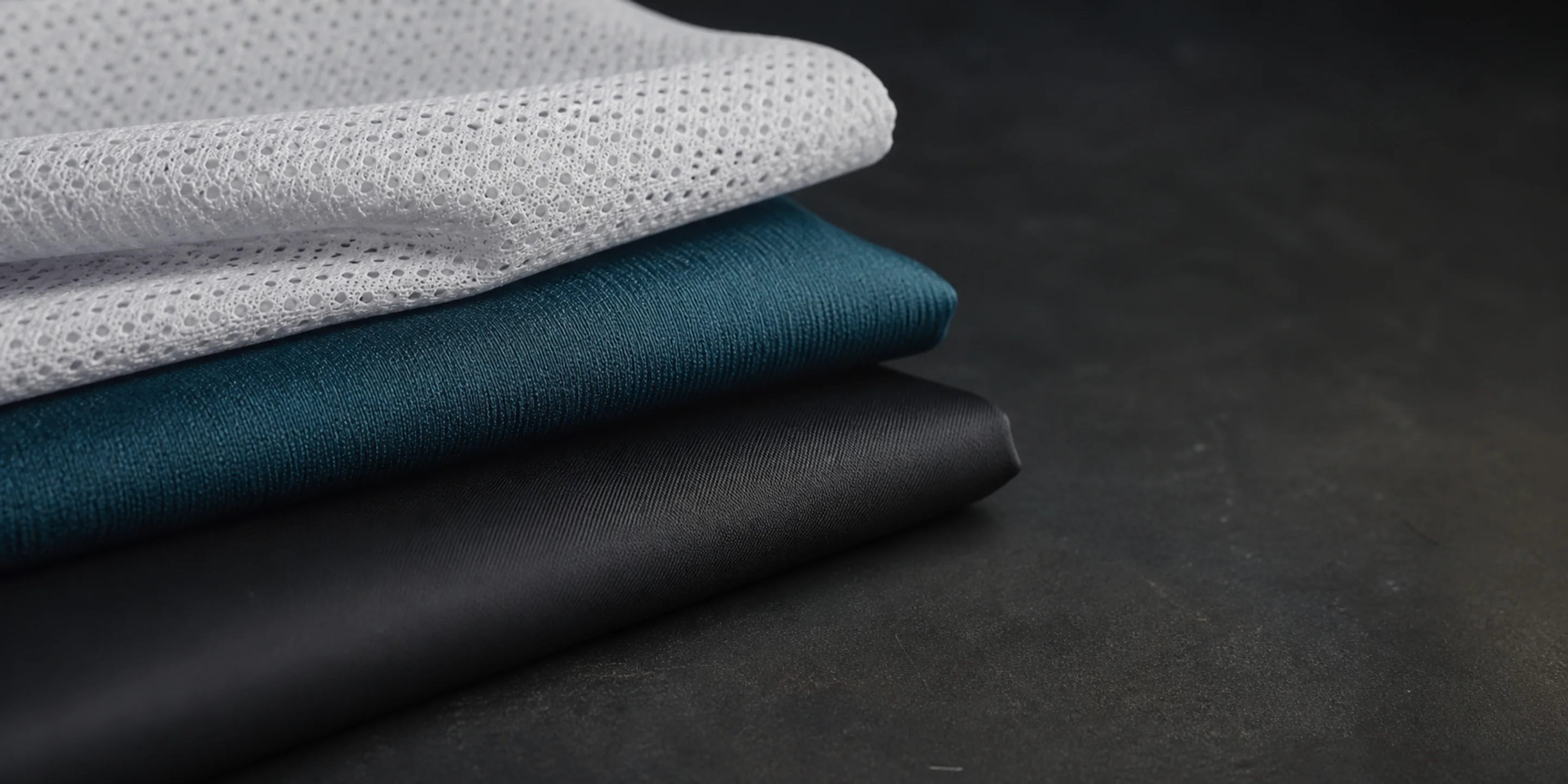 Close-up of folded cycling apparel fabric swatches in a workshop
