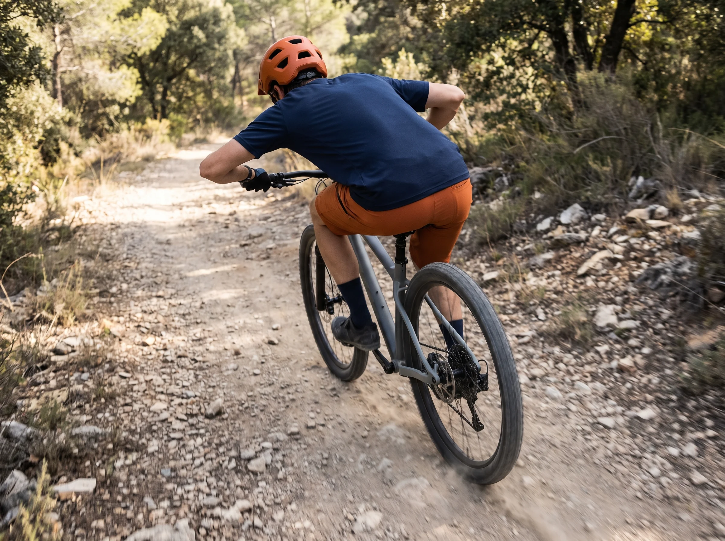 Rider stretched out of the saddle on a loose stony climb