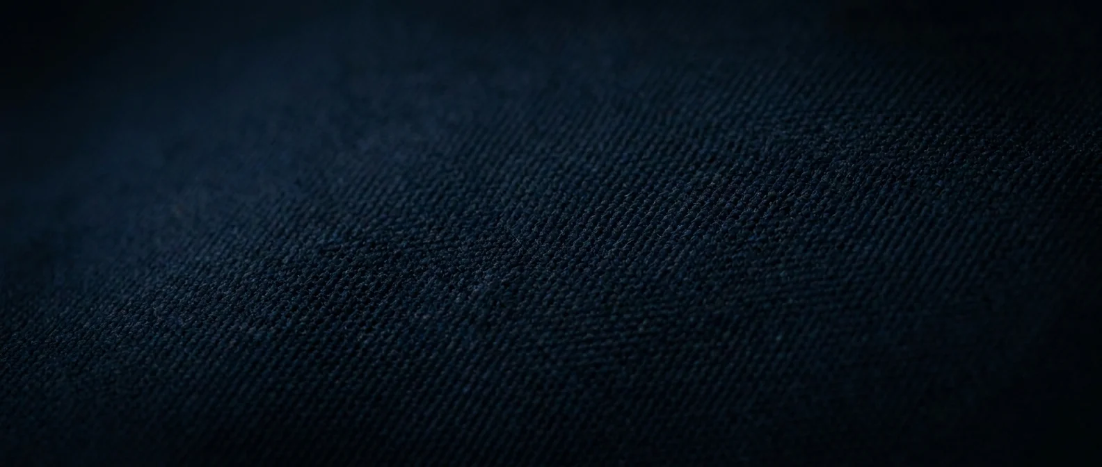 Dark navy technical knit seen close, its structure just catching the light