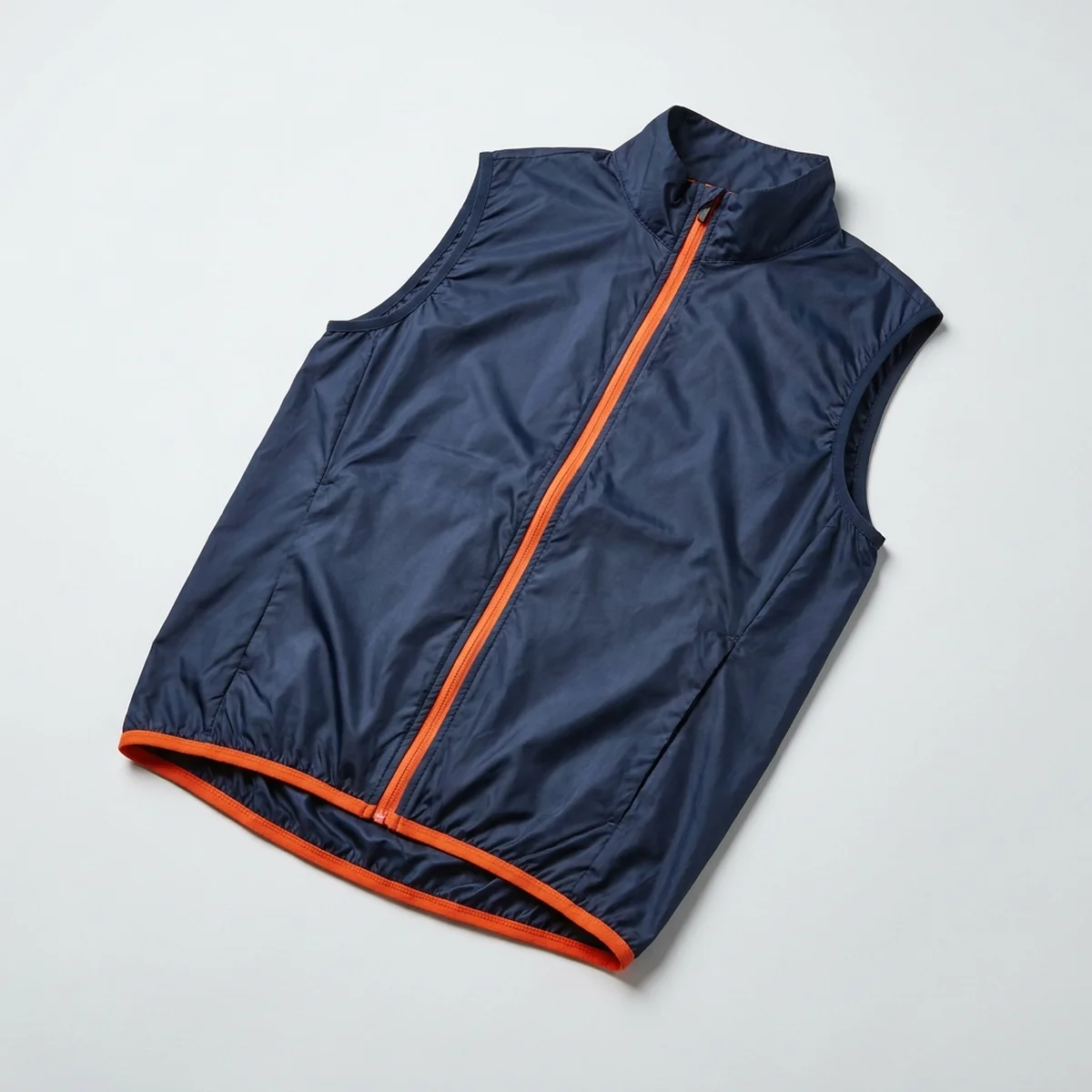 Navy gilet with an orange trimmed hem, laid flat