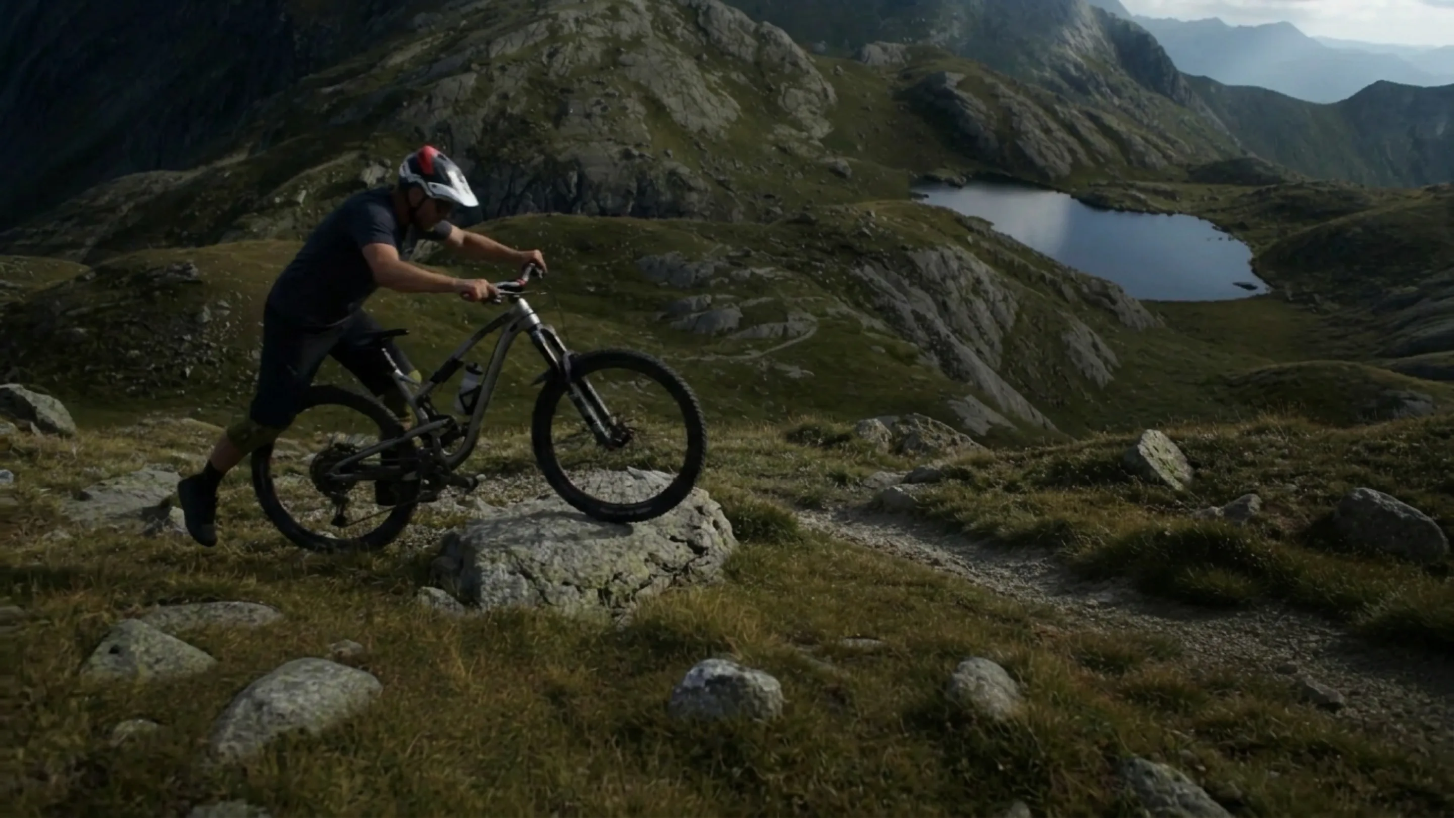 Mountain biker rolling a bike over a rock on a technical alpine singletrack trail