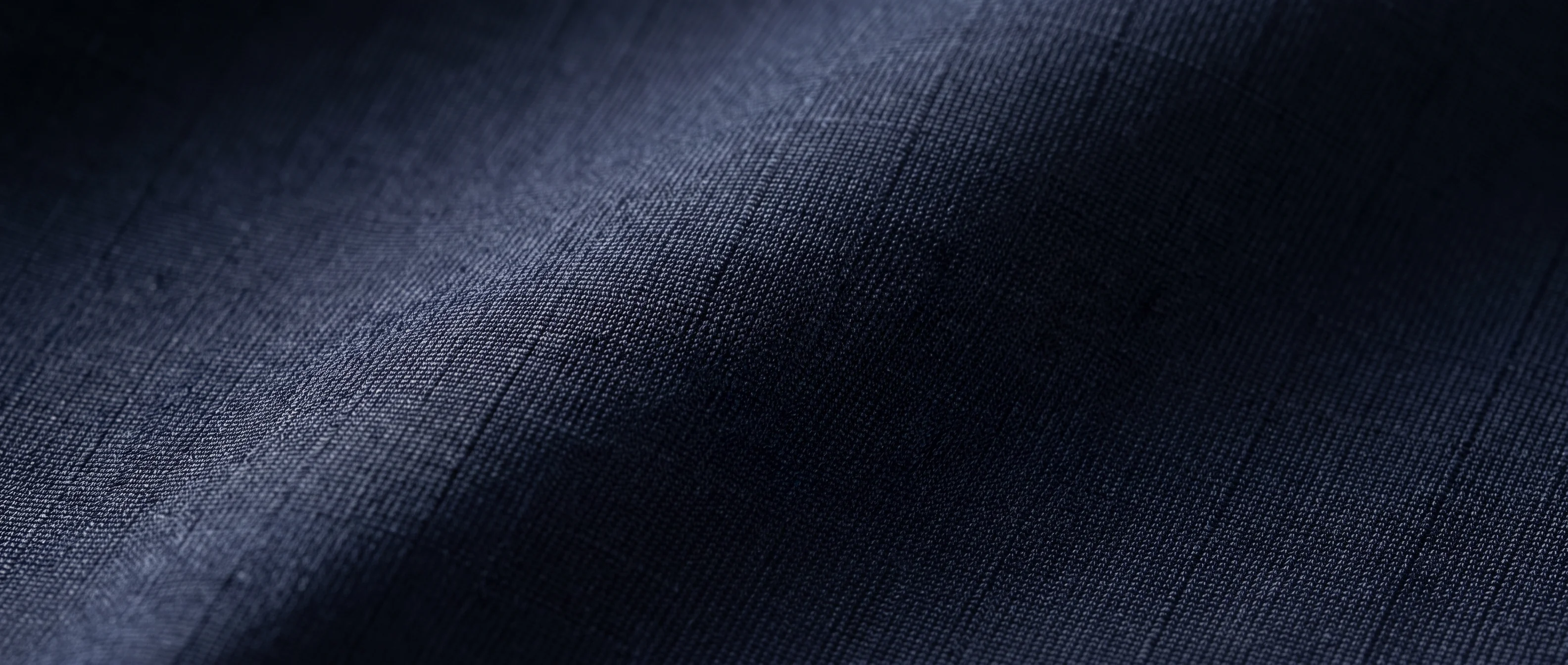 Dark technical fabric texture used as a subtle break-band background