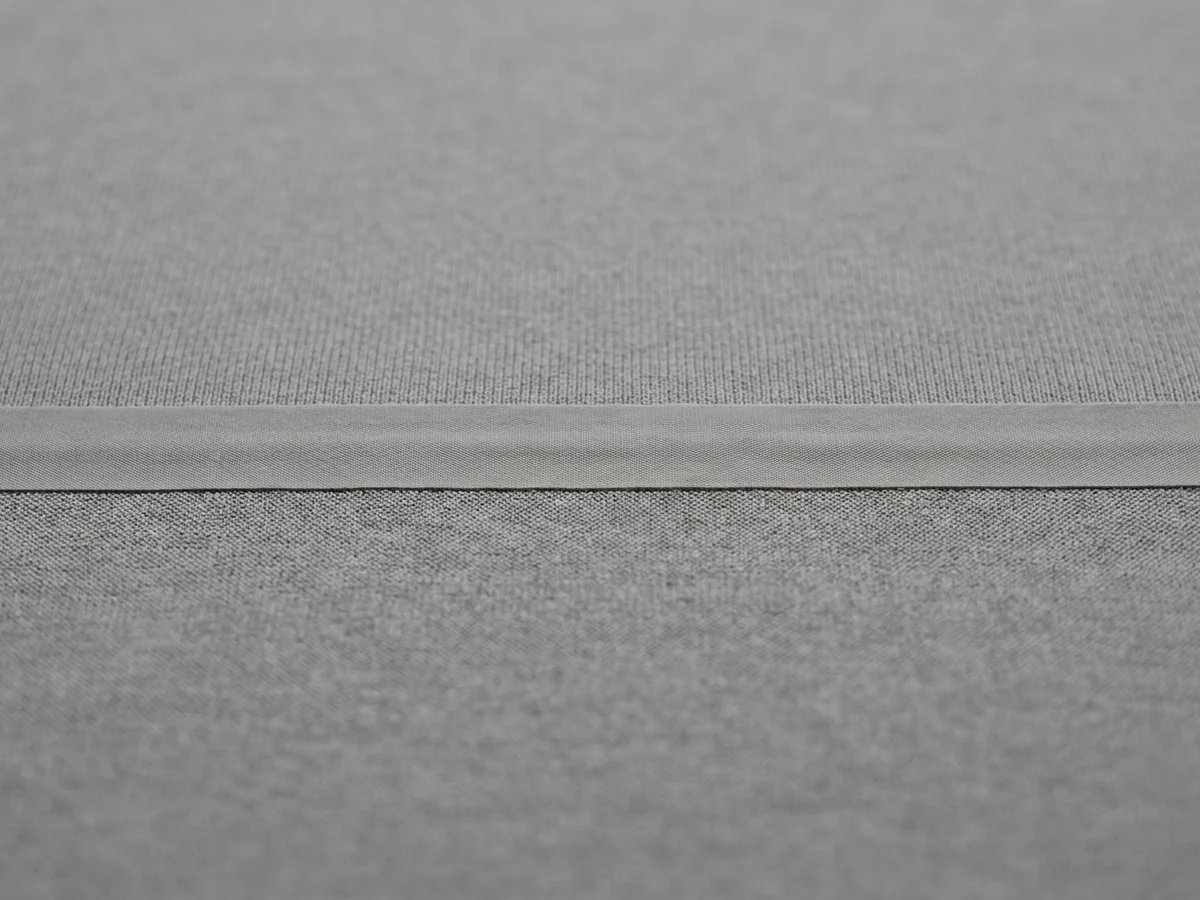 Macro of a bonded taped edge on grey performance knit lying flush with no stitch line along it