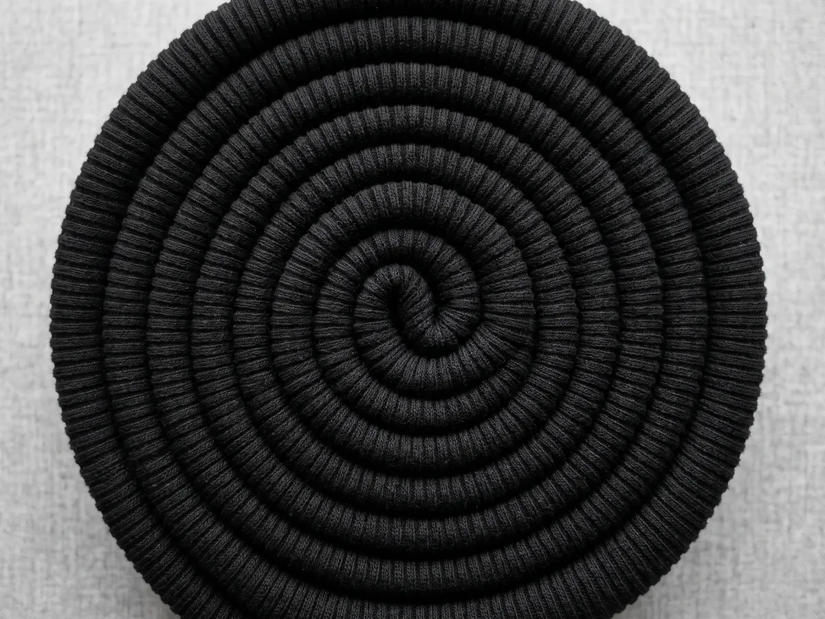 A black ribbed knit fabric drawn into a spiral