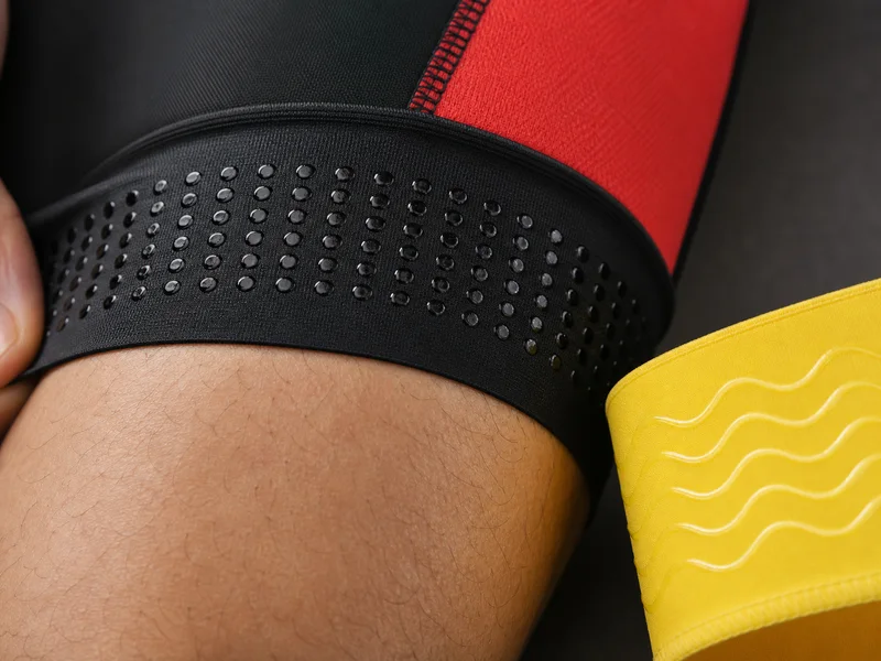 Close-up of silicone anti-slip gripper dots inside a bib short hem