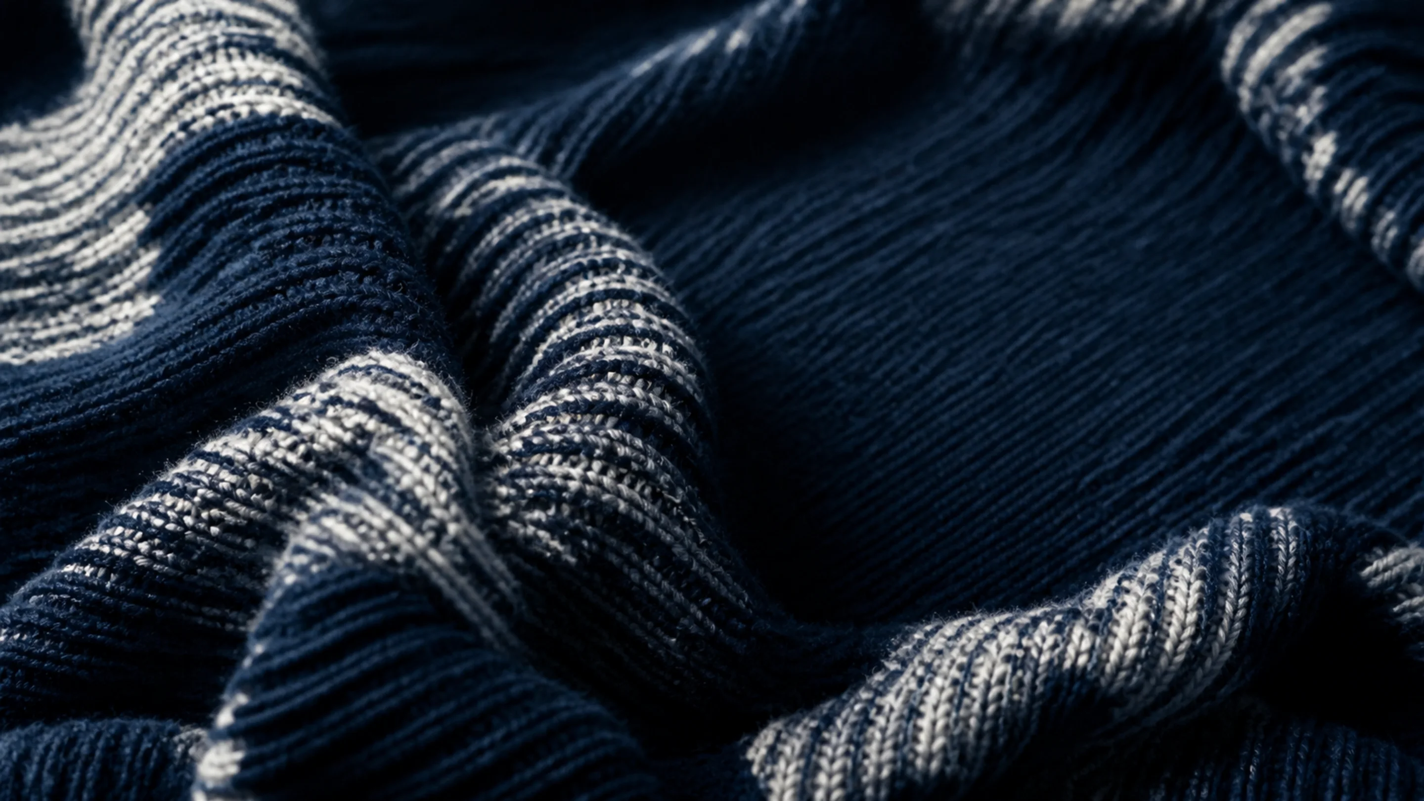 Macro of deep navy technical knit fabric with controlled folds